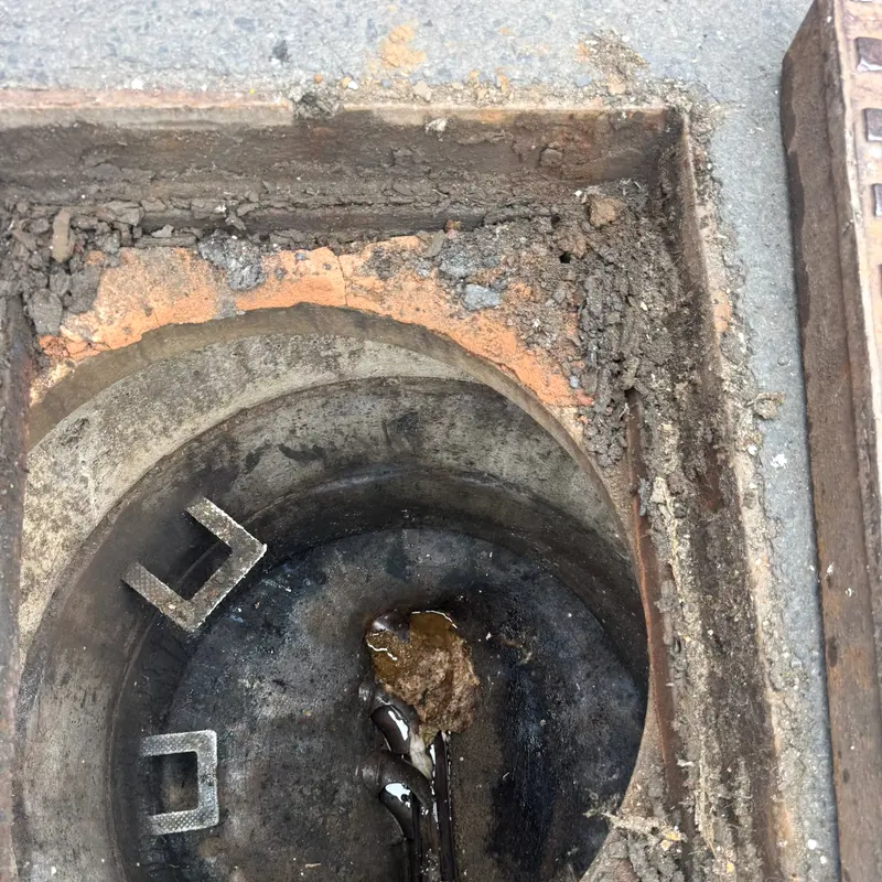 Silt and debris standing in the channel of a manhole